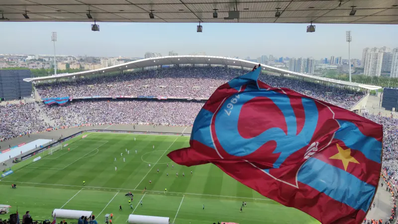 Tribünde dalgalanan dev Trabzonspor bayrağının ardında dolu stat ve yeşil saha