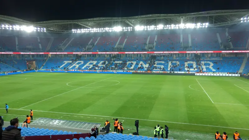 Papara Park'ın bakımlı çim zemini ve tribünde kartonlarla yazılmış Trabzonspor yazısı